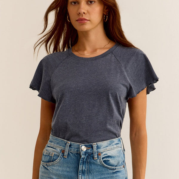 front view of the model wearing the abby flutter tee. shows the flutter sleeve detail. also shows the scoop neckline and relaxed fit. 