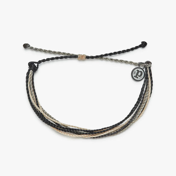 front view of the per rescue bracelet. shows the pull closure. also shows the different colors of black, tan and grey, the pura vida charm in the corner. 