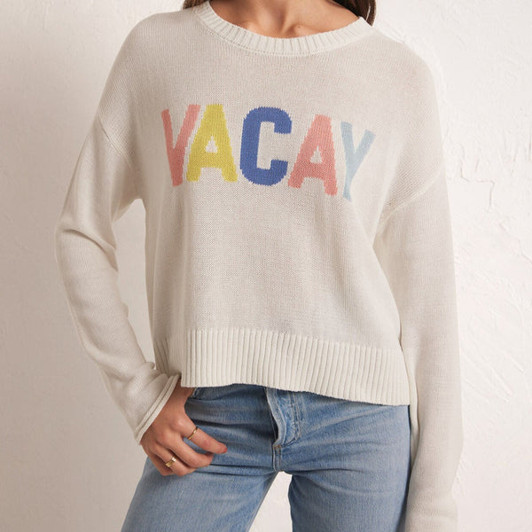 front view of the model wearing the sienna vacay sweater. shows the dropped shoulders. also shows the crew neckline, the ribbed detail on the neckline and bottom hem and the front VACAY wording. 