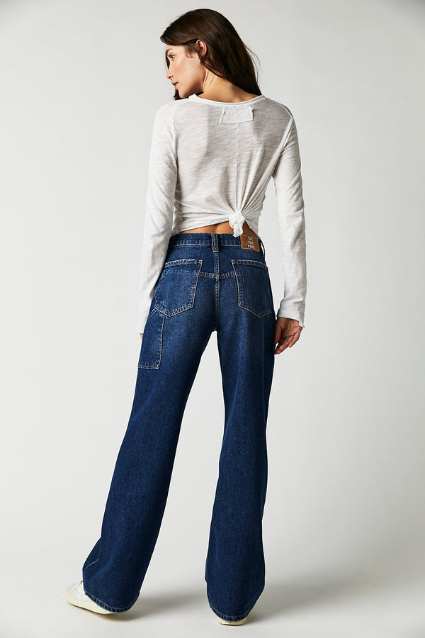 Back view of model wearing jeans. Shows the back two pockets. Also shows one of the side utility inspired pockets and the belt loops. 