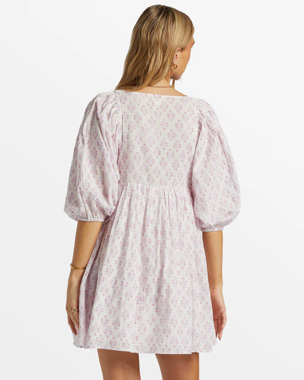 back view of the model wearing the ambers babydoll dress. shows the mini length. also shows the 3/4 puff sleeves, and the floaty fit. 