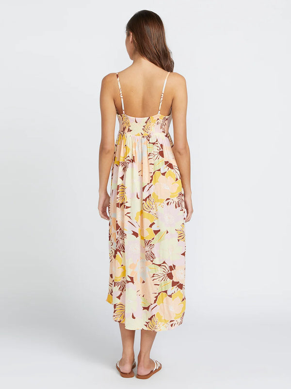 back view of the model wearing the oh lei maxi dress. shows the smocked backing. also shows the spaghetti straps with adjusters, the all over print and the high lo hemline. 