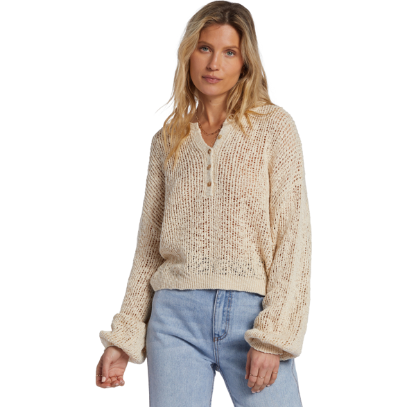 front view of model wearing the warmin up sweater.  shows the dropped shoulders. also shows the boxy fit, the top button closure and the oversized sleeves. 