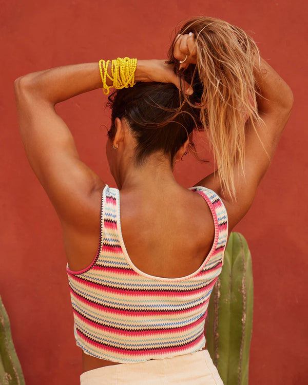 back view of the model wearing the keep it wavy printed ribbed tank top. shows the back scoop neckline. also shows the lettuce trim edge, the fitted fit and the cropped length. 