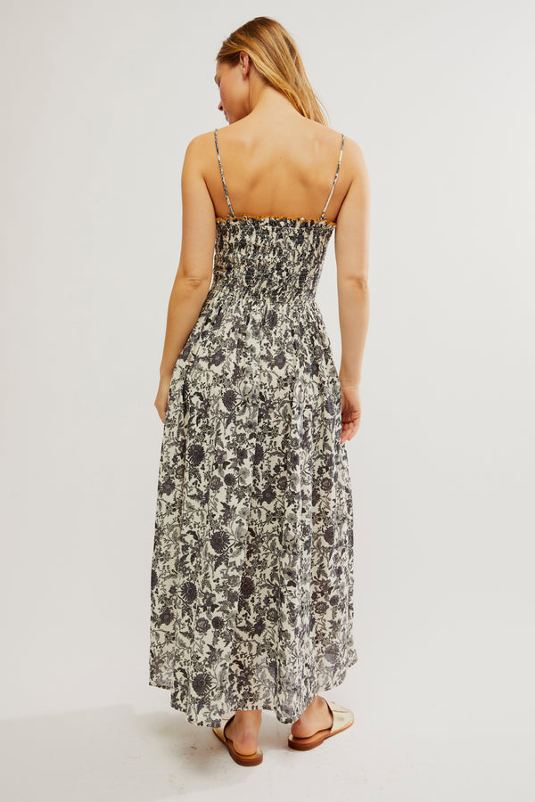back view of the model wearing the sweet nothings midi dress. shows the smocked bodice. also shows the midi length, the thin straps and the side pockets. 