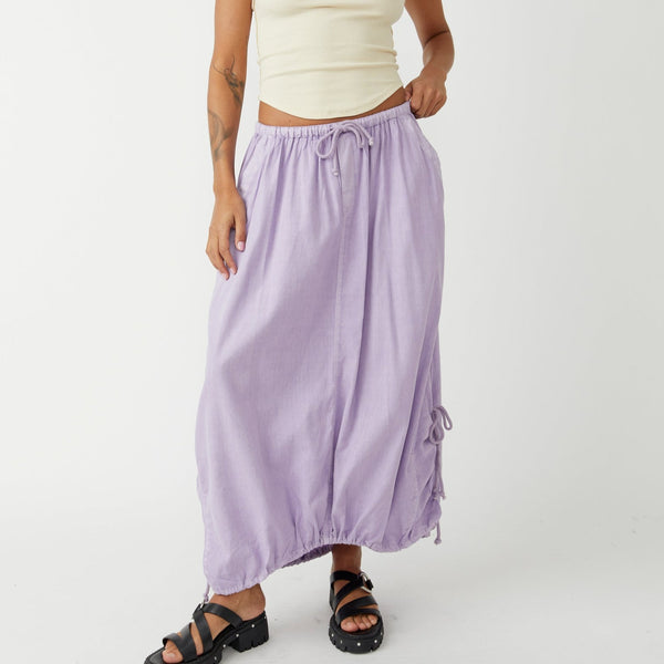 front view of the model wearing the picture perfect parachute skirt. shows the elastic, drawstring waist. shows the drawstring detail at the bottom curved hem and the side pockets. 