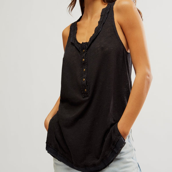 front view of the model wearing the love language tank. shows the half front button closure. the raw seaming, the dropped shoulders and the side slits. 