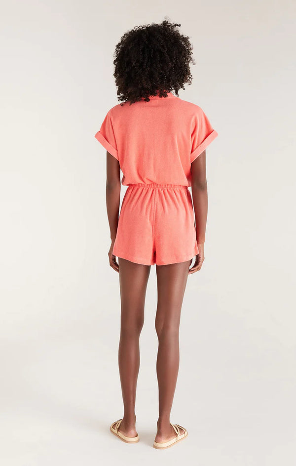 Back view of romper. Shows dropped, rolled sleeves with elastic back waistband.