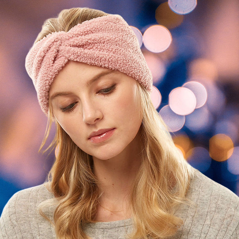 front view of model wearing earmuff headband. Shows the front tie knot detail and the sherpa fleece material in this pink color.  