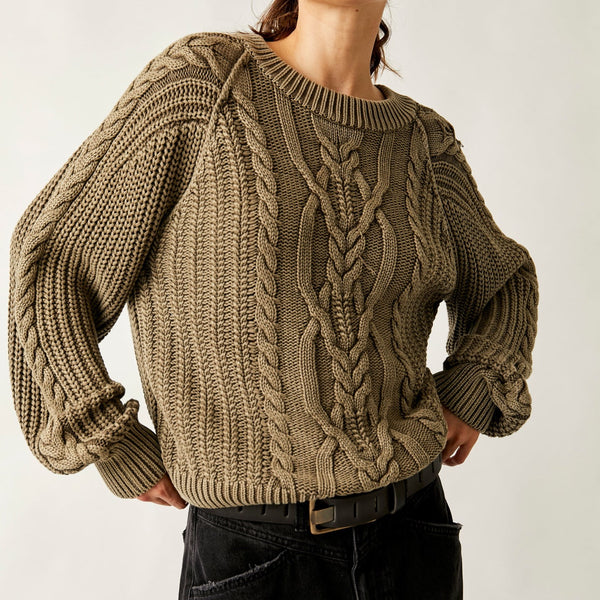 front view of model wearing Frankie cable sweater in olive stone. shows the scoop neckline. also shows the ribbed hems, slouchy, relaxed fit and the knot sweater detail thought the body and arms of the sweater. 