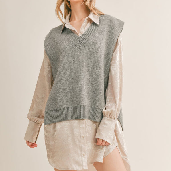 Front view of model wearing sweater vest. Shows the v neckline. Also shows the ribbed hem and cap sleeves. 