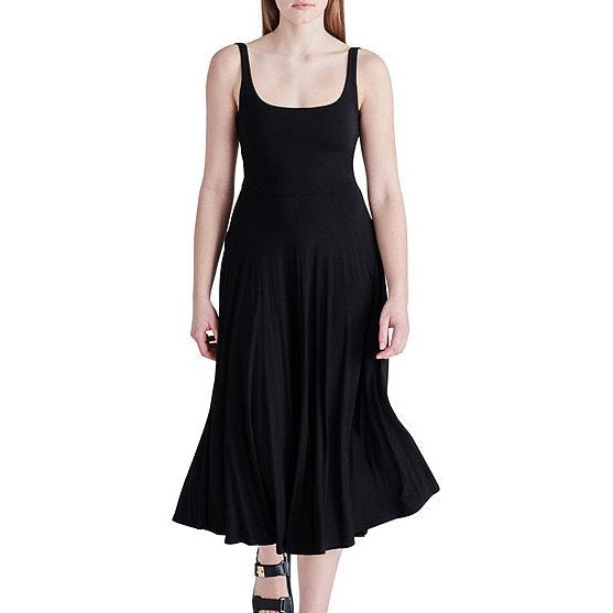 front view of model in dress. shows a scoop neckline with fixed straps. shows the fitted bodice and the flowy skirt. hits model at mid calf.