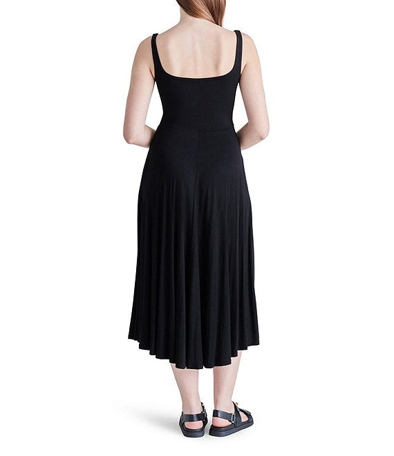 shows back view of model in dress. you can see the scoop back and flowy skirt.