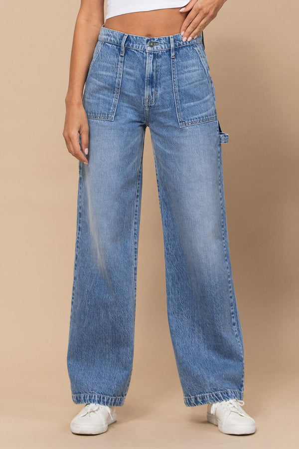 front view of model wearing jeans. you can see the high waist, faded thighs with whiskering, side patch pockets, wide legs and a tool loop on the side.
