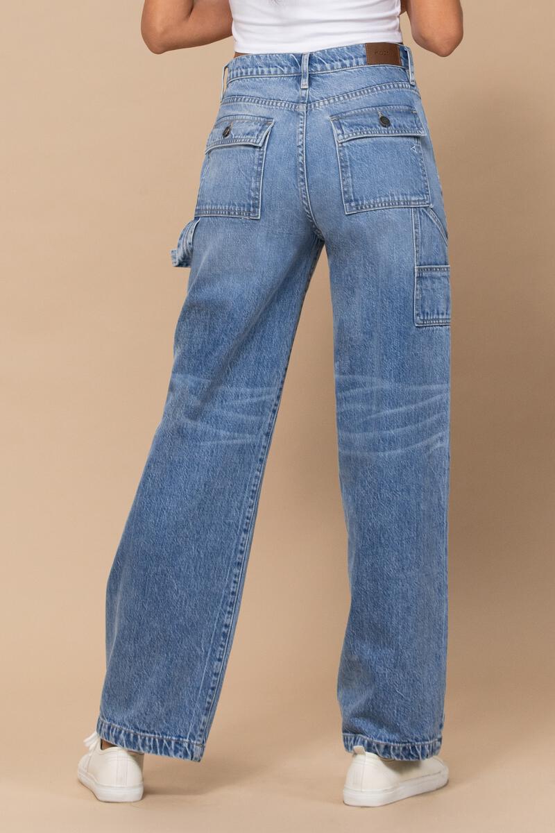 back view of model wearing jeans. there are two back pockets with flap closures. you can see the little tool holder loop on the side as well as some whiskering detail behind the knees.