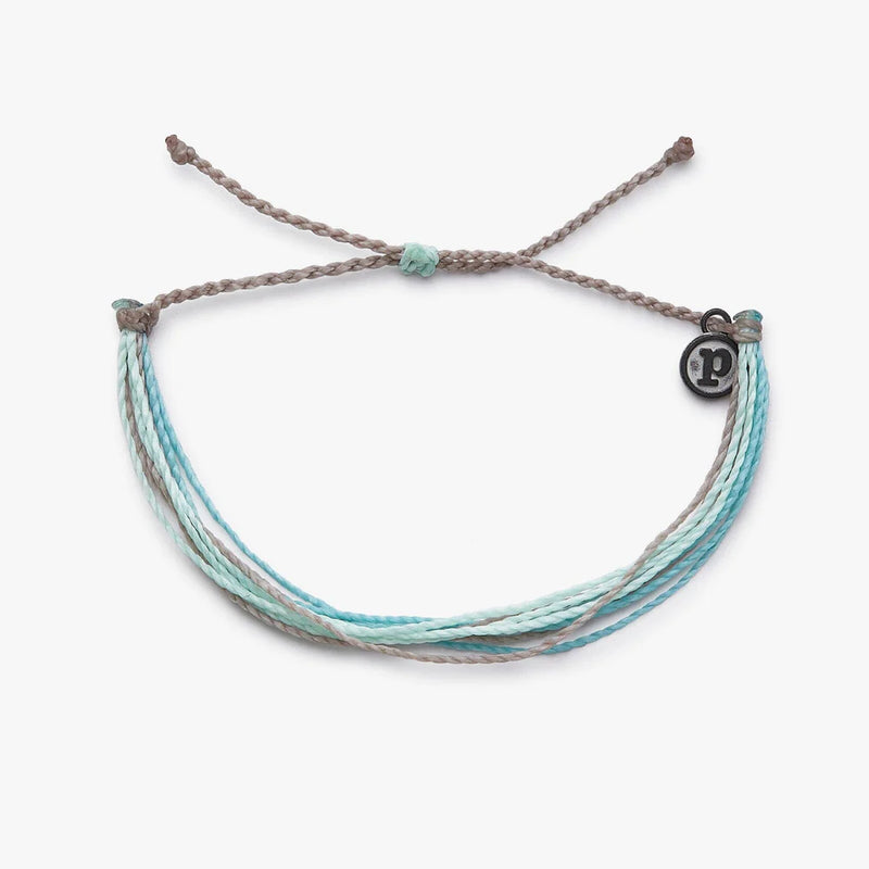 Shades of blue wax coated multi string bracelet with adjustable ties. Has a mini circle charm with "P" in the center.