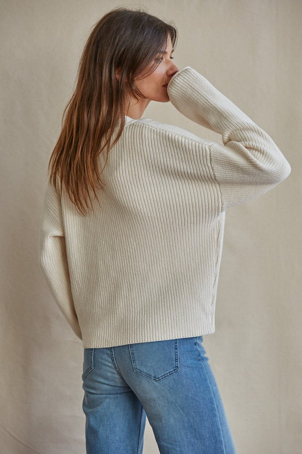 shows a back view of model in cardigan. here you can see the dropped shoulders, and boxy fit.