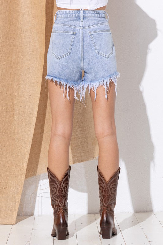 back view showing frayed shorts with back pockets on either side and hitting high on the back of the thighs