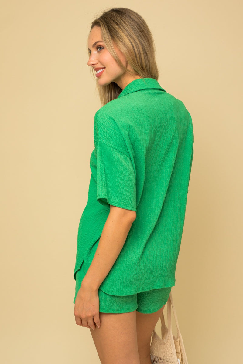 Shows the back of the shirt. Shows oversized fit, dropped shoulders and side slits.