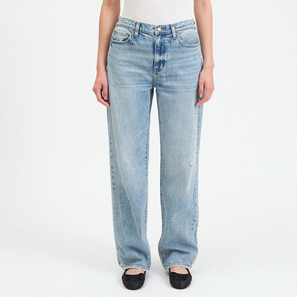 front view of the model wearing the 1999 slouch jeans. shows the mid rise. also shows the relaxed fit, the slouchy loose legs and the light denim color. 