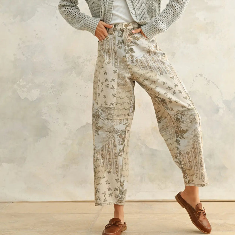 front view of the model wearing the dorothy printed barrel pants. shows the high-rise waist. also shows the all over floral pattern, the barrel style, and the ankle length. 