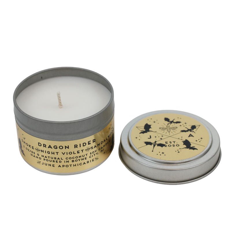 Candle in a tin with 'Dragon Rider' label on a white background