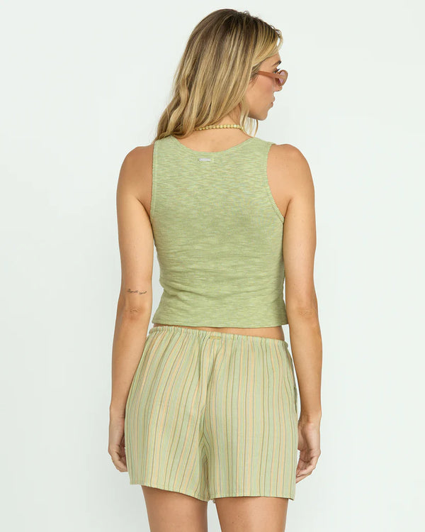 back view of the model wearing the bren knit vest. shows the cropped length. also shows the green color, the slim fit and the thicker straps. 