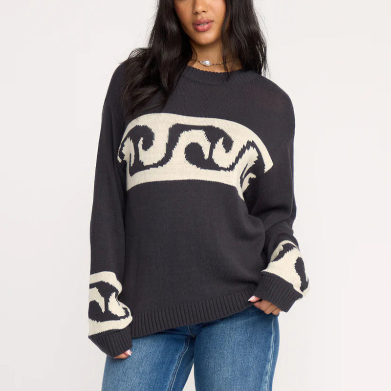 Woman wearing a black sweater with white patterns on a white background