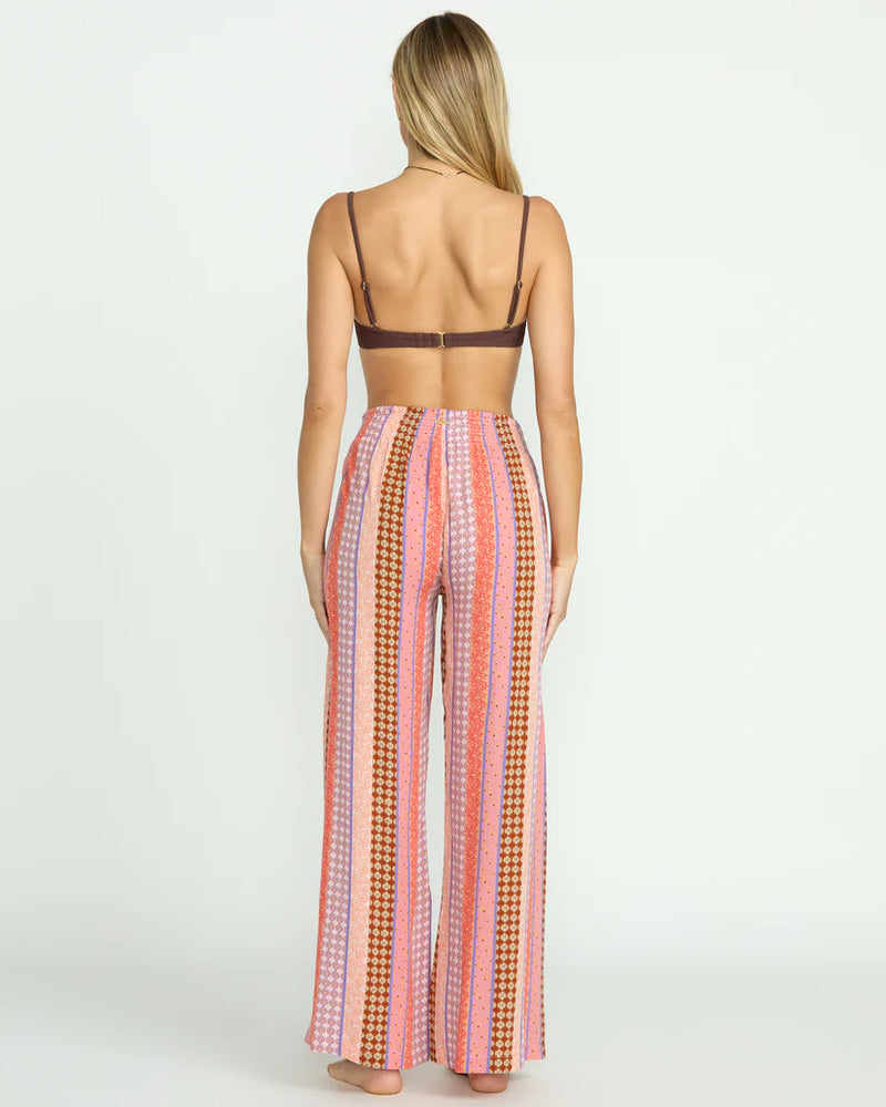 back view of the model wearing the split spirit elastic waist pants. shows the high rise. also shows the full length, the striped pattern and the relaxed fit. 