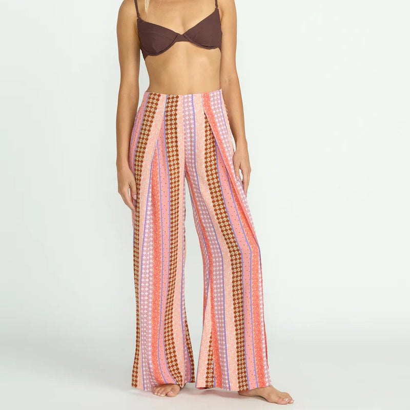 front view of the model wearing the split spirit elastic waist pants. shows where the front slits are. also shows the striped design, the relaxed fit and the elastic waist. 