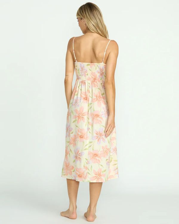 back view of the models wearing the sunset love dress. shows the smocked bodice. also shows the adjustable straps, the midi length and the floral print. 