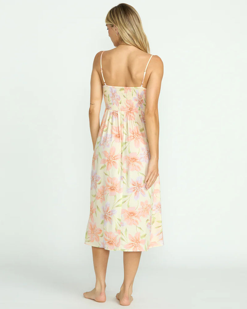 back view of the models wearing the sunset love dress. shows the smocked bodice. also shows the adjustable straps, the midi length and the floral print. 