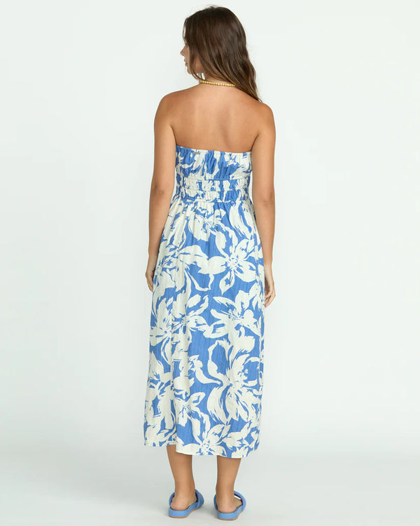 back view of the model wearing the in the sky midi dress. shows the midi length, the strapless top and the elastic waist. 