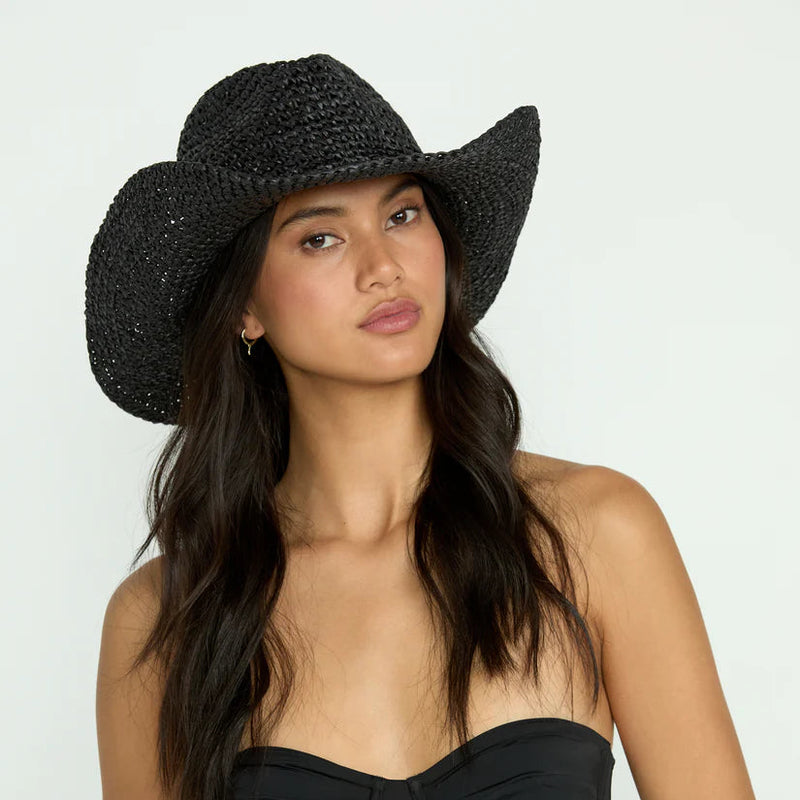 front view of the model wearing the take it west hat. shows the straw material. also shows the flipped up sides and the black color. 