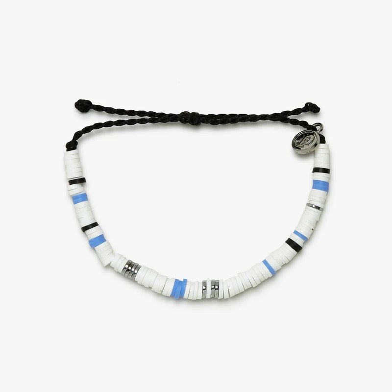 Bracelet is laying on a flat surface which showcases the black wax coated adjustable string and the small circular charm with a "P" in the center.