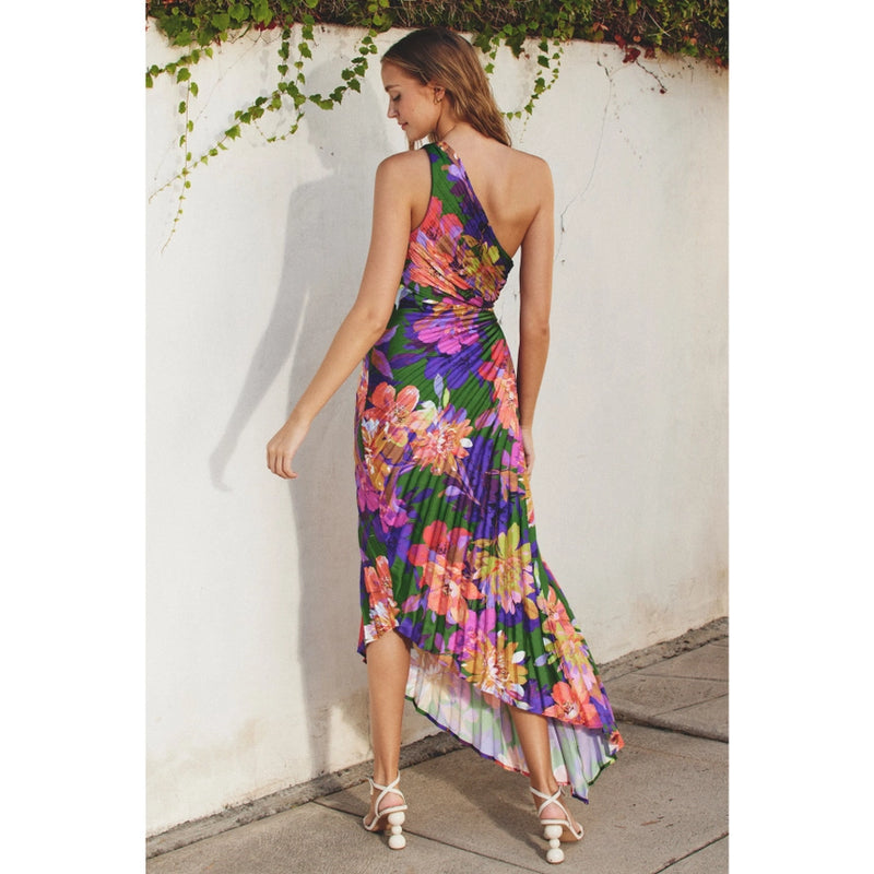 back view of the model wearing the make an entrance maxi dress. shows the asymmetrical neckline.  also shows the the pleating throughout & the asymmetrical bottom.  