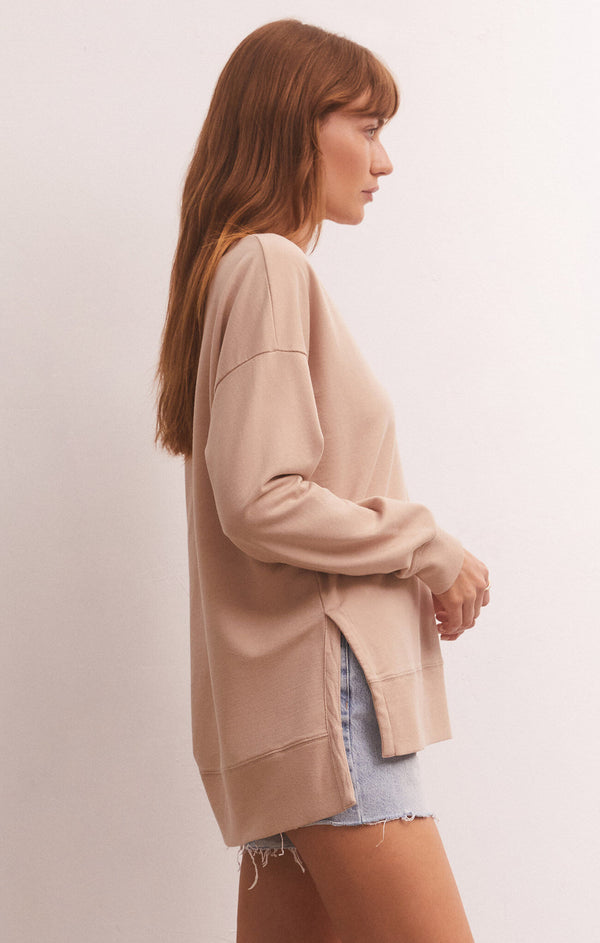 side view of model in shirt. shows the dropped shoulders, side slits and hi-low hemline.