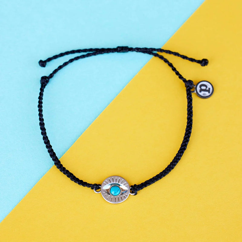 Shows bracelet on flat surface. Shows circular eye charm with turquoise center stone. 