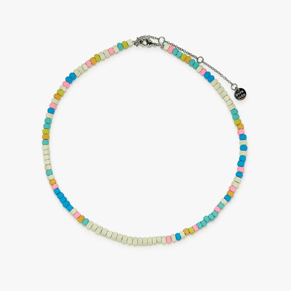 The multi colored hematite bead necklace is clasped and laying on a flat surface. The adjustable chain is visible.