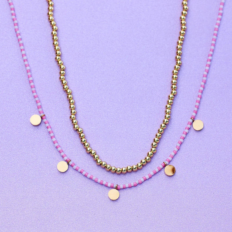 necklace laying on flat surface. shows gold: brass base with gold plating & glass seed beads