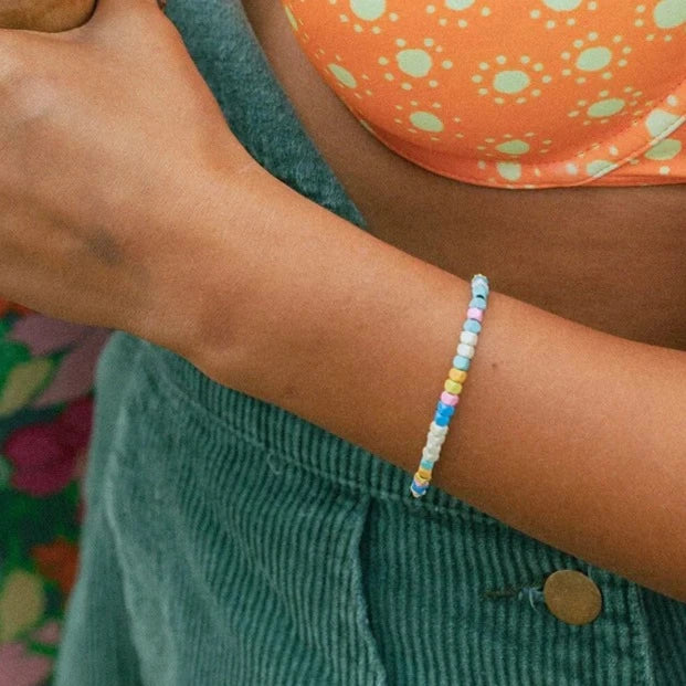 Shows bracelet on models wrist. Bracelet has multi colored hematite beads.
