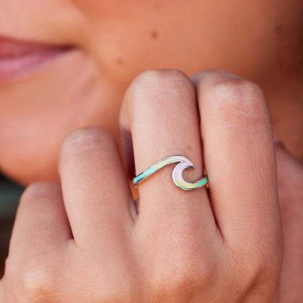 Shows ring on models finger. Ring in shape of wave with multi colored enamel.