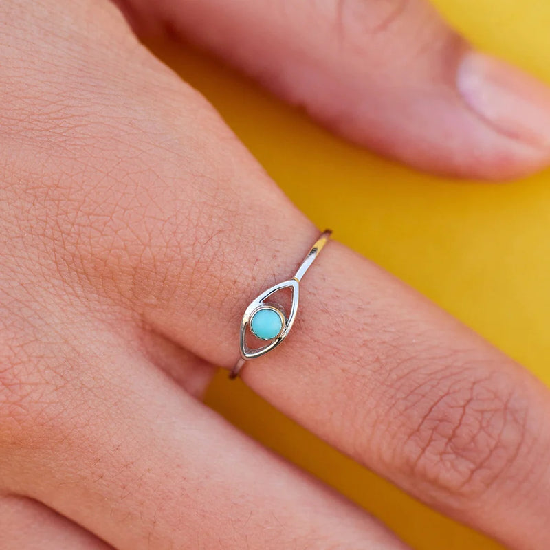 Shows silver ring on models finger. Has an eye with turquoise stone in center.- Natural stones: 3mm diameter - Protective eye: 6mm (W) x 3.5mm (H)