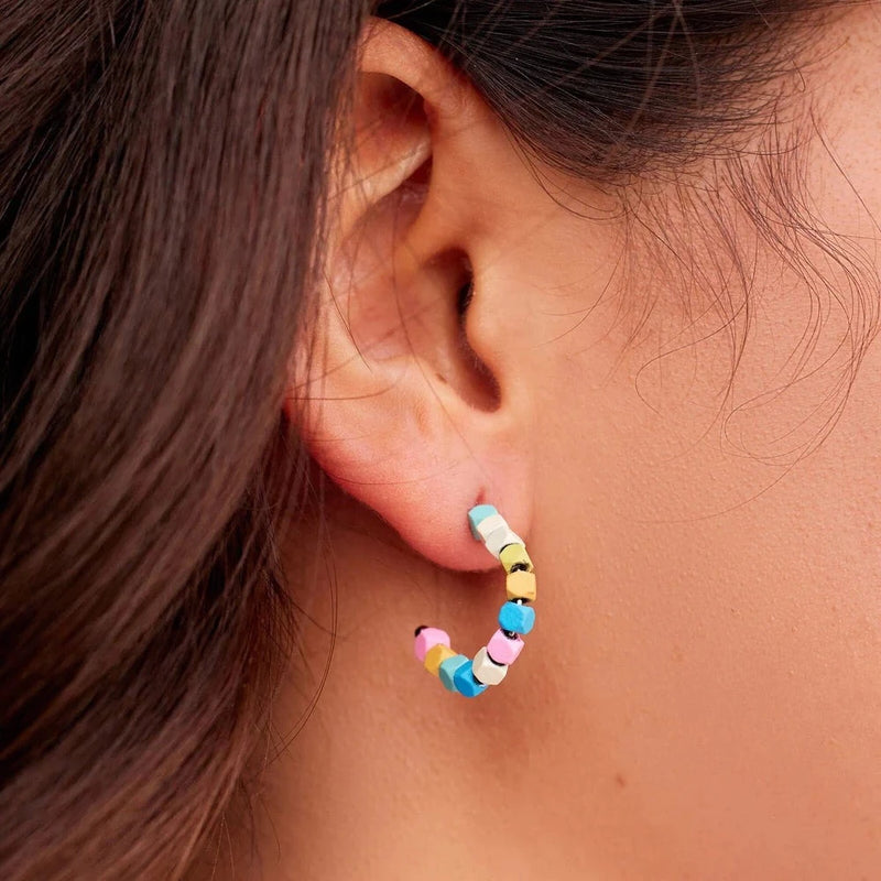 Shows the half hoop earring in models earlobe. Showcases the multi colored hematite beads.