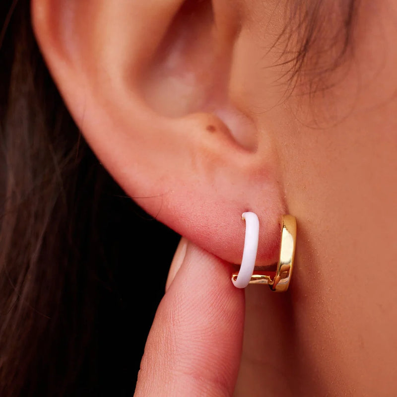 Gold colorway earring is shown in models ear. Gives the illlusion of 1 mini white enamel hoop and 1 mini solid gold hoop.