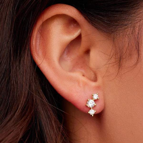 Shows earrings on models ear. Stacked crystals in a a slight curve.