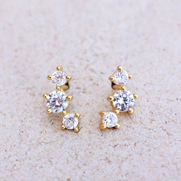 Shows earrings sitting on a flat surface. 