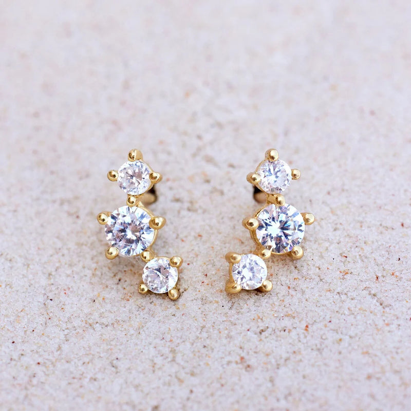 Shows earrings sitting on a flat surface. 