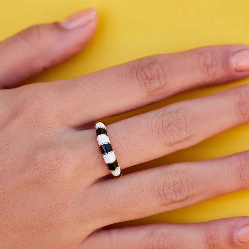 Shows dome shaped ring on models middle finger. Black and white striped enamel design.