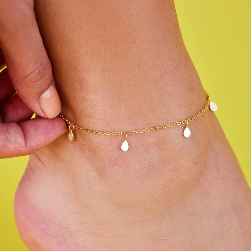 A close up of the anklet on models ankle. The 5mm (H) x 3.5mm (W) teardrop charms are shown.